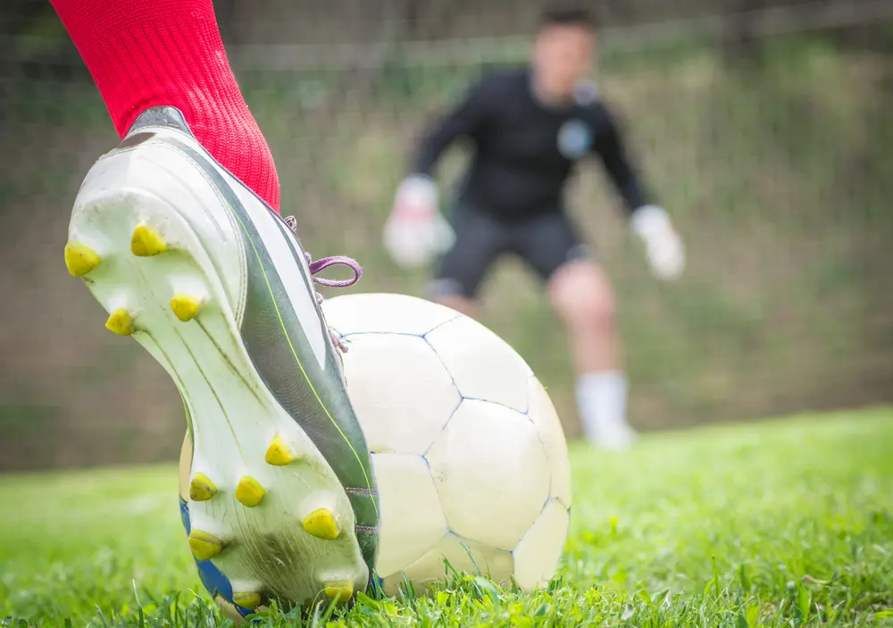 Okanagan Vision Therapy - A soccer player is ready to hit the ball. Goalkeeper is gonna dive on the left